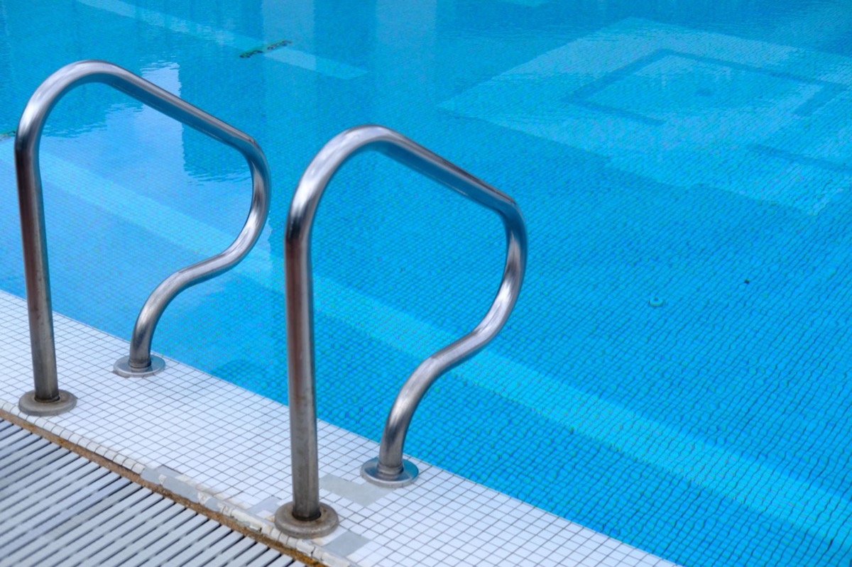 borde de piscina con baldosas y agua azul
