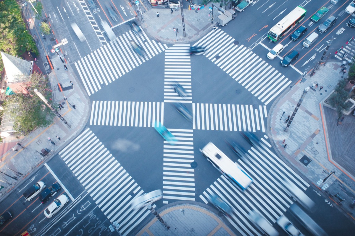 Red traffic lights and parked cars at a city intersection