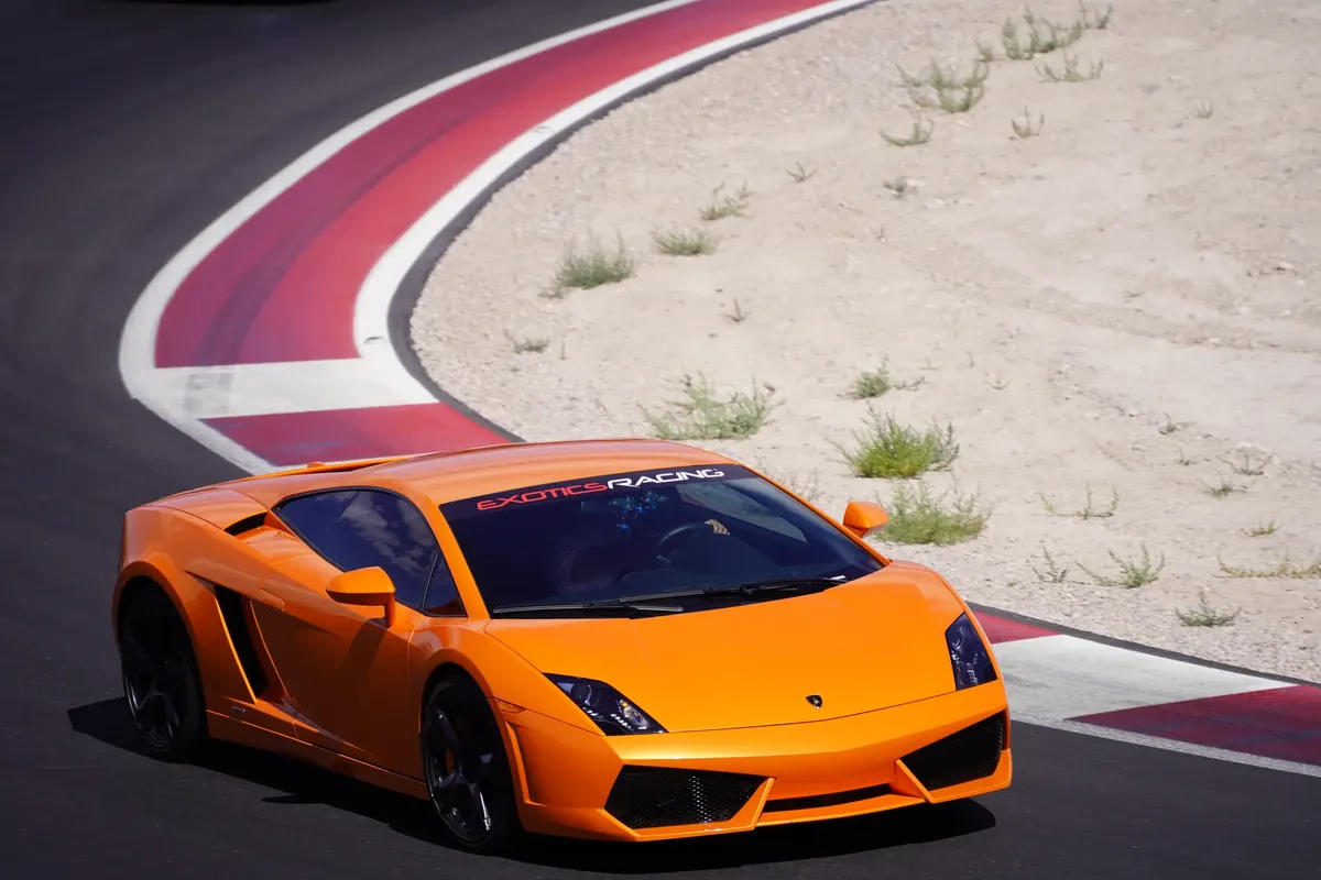 Dynamic shot of a bright orange Lamborghini racing on a Las Vegas circuit.