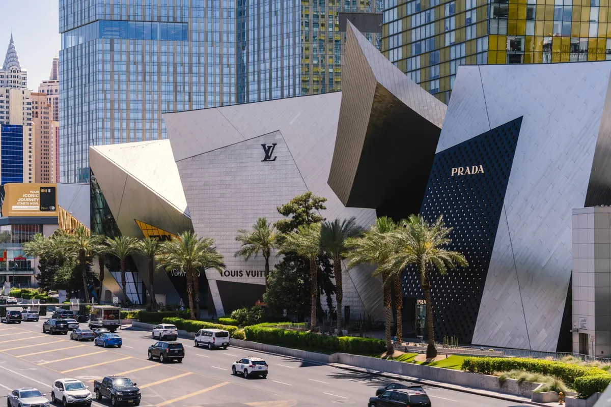 A modern Prada storefront on the Las Vegas Strip with iconic city architecture in view.